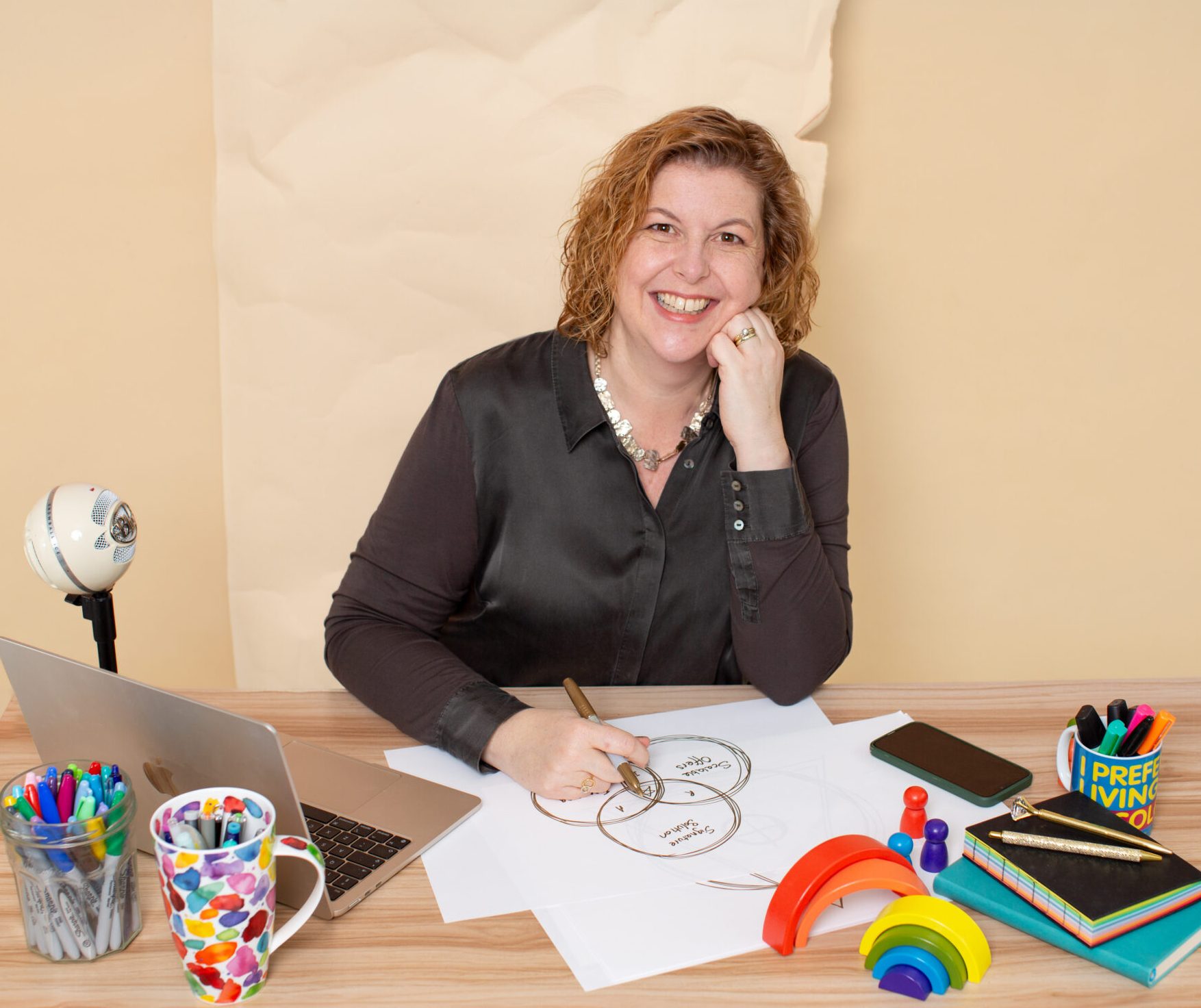 Susanna Reay, Creative Business Coach, Author, Speaker Susanna Reay at her colourful desk with a framework sketched in front of her.